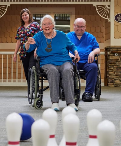 Residents and staff enjoying a bowling activity indoors