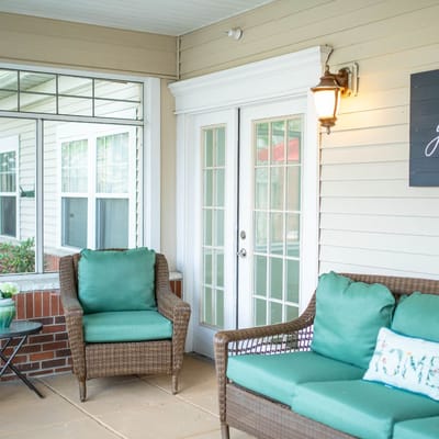 Cozy seating area on a porch with green cushions