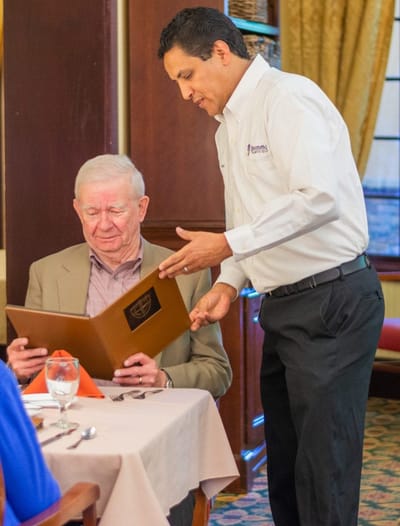 Staff assisting resident with menu in dining room