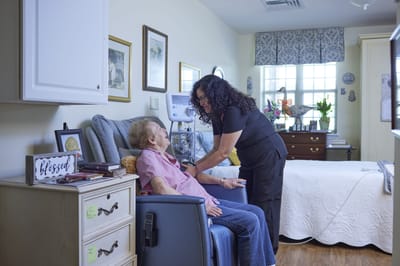 Staff assisting resident in a cozy room
