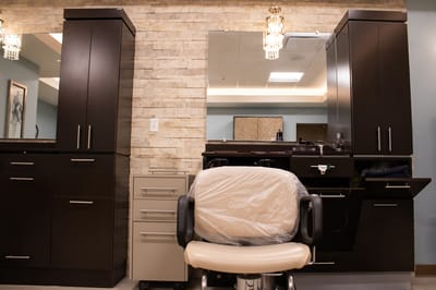 Interior view of a hair salon area with chair and cabinetry