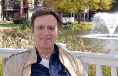 Monroe Village Assisted Living, nursing home in Monroe Township, NJ — Smiling man sitting near a fountain in a garden