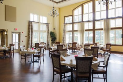 Bright dining room with large windows and tables set for meals
