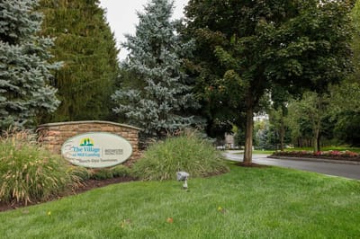 Entrance sign for The Village Townhomes in a landscaped area