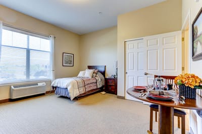 Cozy resident room with a bed, table, and decor