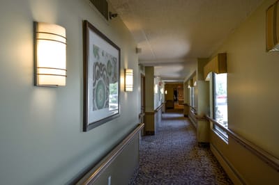 Well-lit corridor with art and lamps