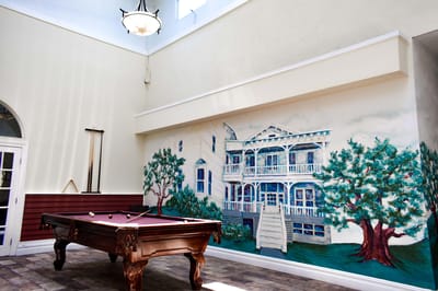 Interior view of a common area with a pool table and mural