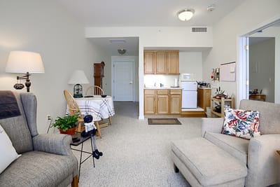 A cozy resident room with seating and kitchen area