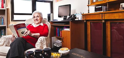 A resident reading a book in a cozy room