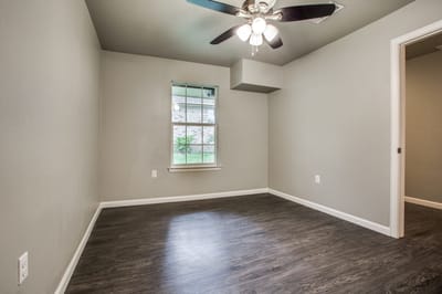Empty resident room with window and ceiling fan