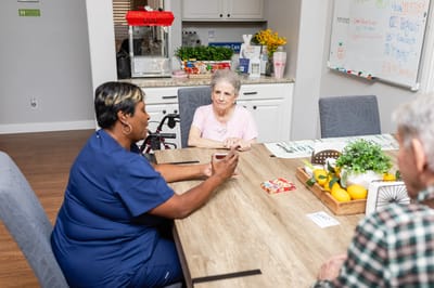 Staff and resident engaging in conversation at a table