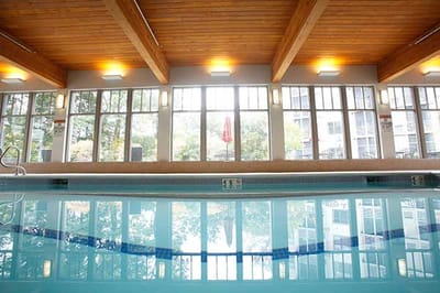 Indoor pool area with large windows and wooden beams