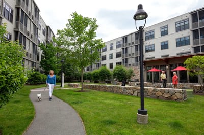 Resident walking a dog in a landscaped outdoor space