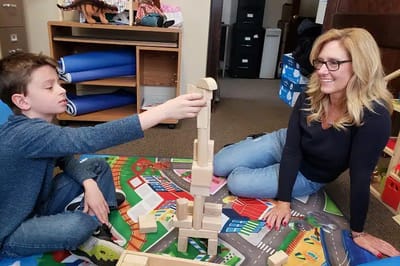 Adult and child playing with block toys