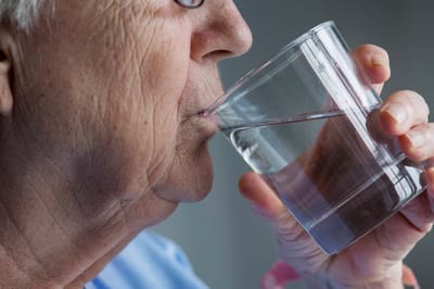 Elderly woman drinking a glass of water