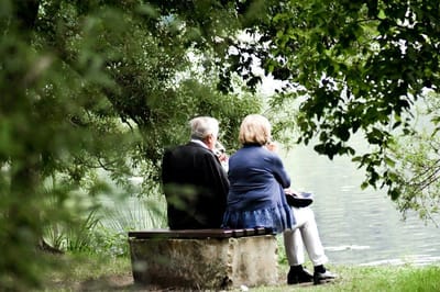 Two seniors enjoying a peaceful moment by the water.