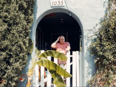 Person at a gate near a colorful building entrance.