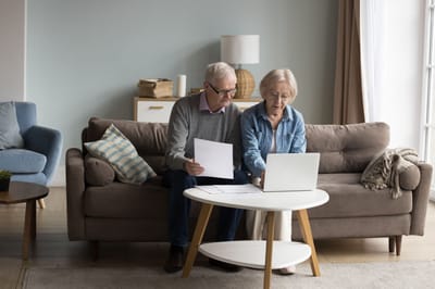 Older couple working together on a laptop