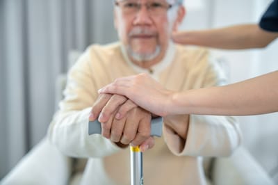 A caregiver holding hands with a senior resident.