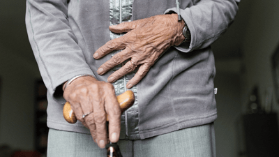 Close-up of a person's hands holding a cane