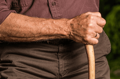 Close-up of an elderly person's hand holding a cane