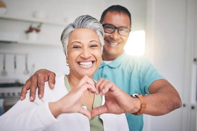 Happy seniors making a heart shape with hands