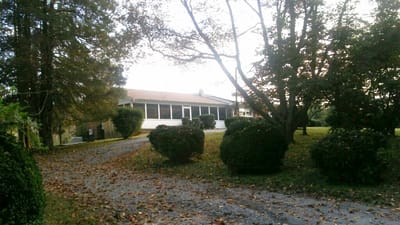 Exterior view of assisted living facility surrounded by greenery.
