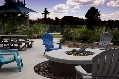 Outdoor seating area with a fire pit and blue chairs