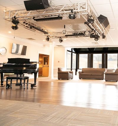 Bright community room with a grand piano and seating area
