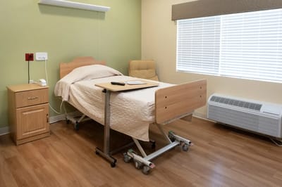 A private resident room with a bed and seating area