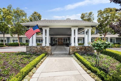 Entrance view of Aegis Living Moraga with American flag