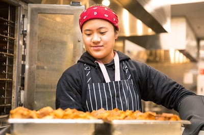 Staff member preparing food in a kitchen