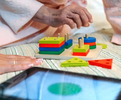 Elderly resident focused on a colorful activity set