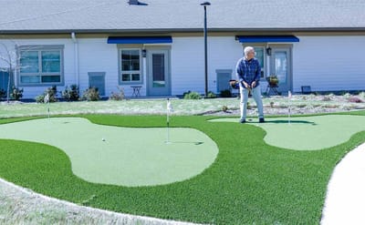 Resident practicing putting on a mini-golf course