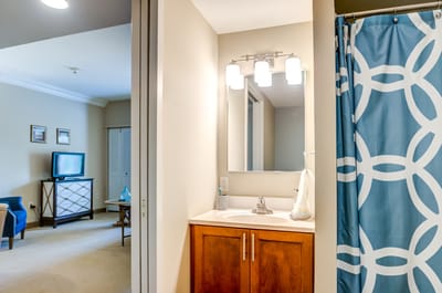 A well-lit bathroom and living space in a resident's room
