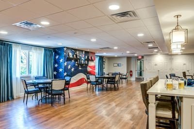 Common area with dining tables and an American flag mural