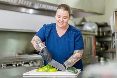 Staff member preparing vegetables in the kitchen