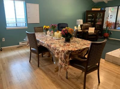 A cozy common area with a dining table and flowers