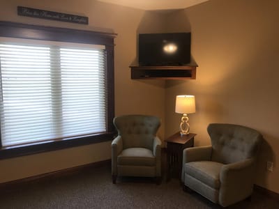 Cozy seating area with chairs and a lamp.