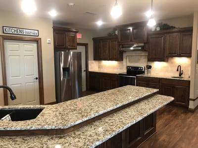Modern kitchen area with wooden cabinets and granite countertops.