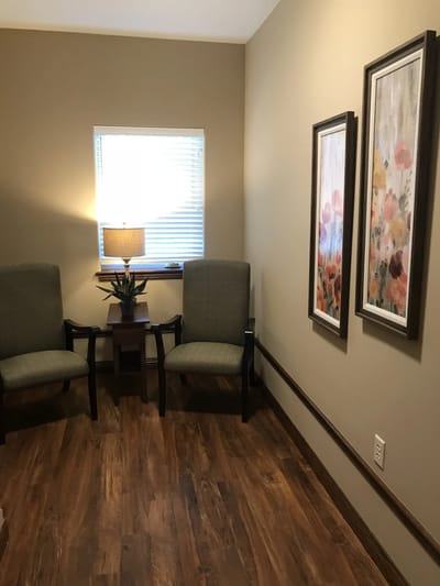 Cozy seating area with artwork and lamp.