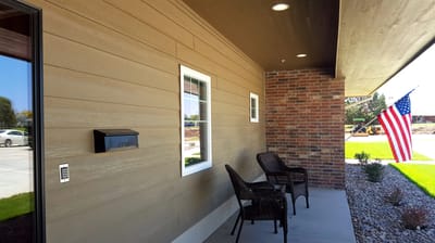 Outdoor seating area with a brick wall and windows.