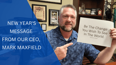 CEO holding a motivational sign in an office setting.