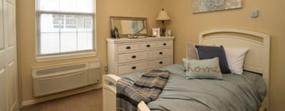 Cozy bedroom with a bed, dresser, and decor