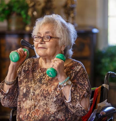 Senior woman exercising with dumbbells indoors