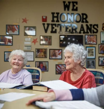 Two smiling residents enjoying an activity indoors