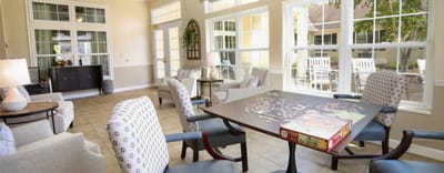 Bright common area with large windows and puzzle activity