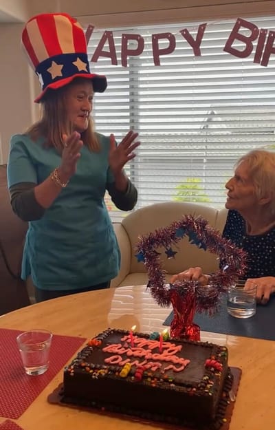 Staff and resident celebrating a birthday with cake