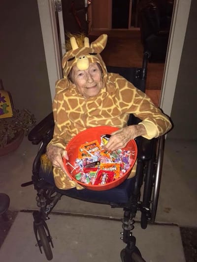 Resident in a giraffe costume handing out candy