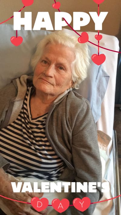 An elderly woman in bed celebrating Valentine's Day
